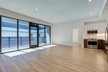 a living room with sliding glass doors to a pool and a kitchen